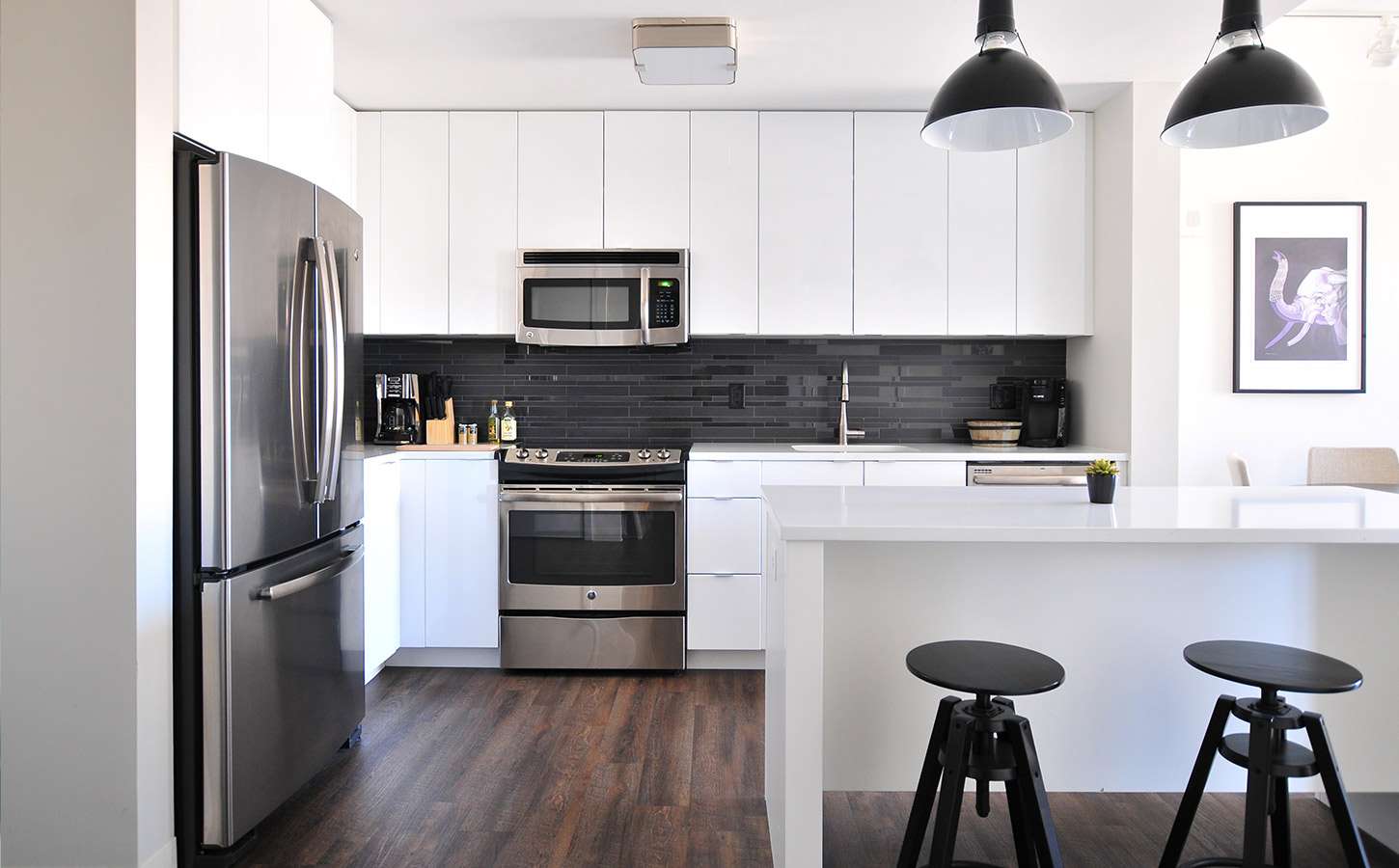 White modern kitchen with stainless steel appliances.